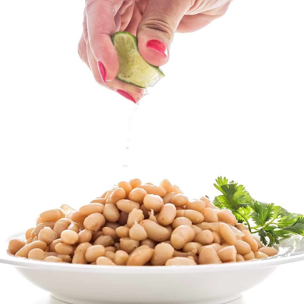 Garnishing cooked beans with lime juice.