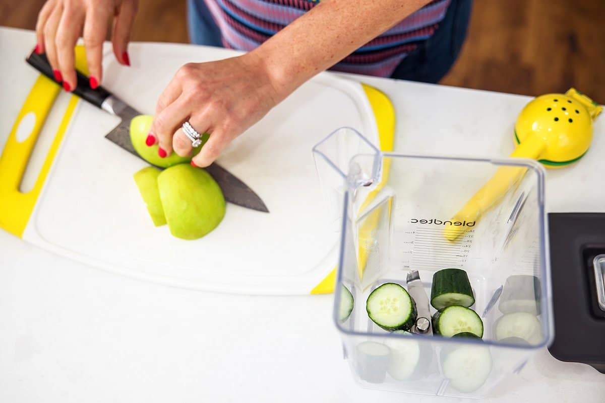 person cutting green apple