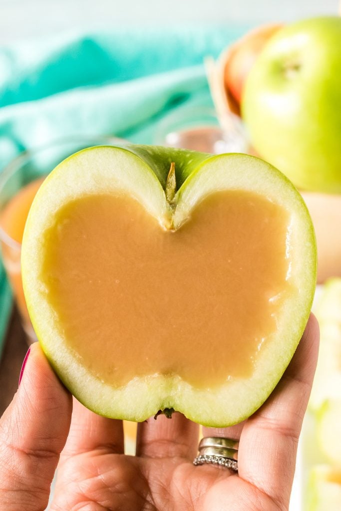 hand holding half an apple filled with caramel