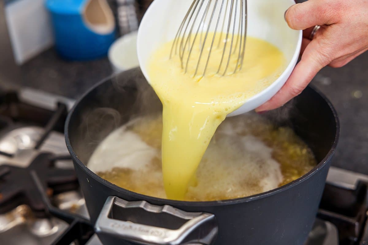 Pouring egg and broth mixture into pot