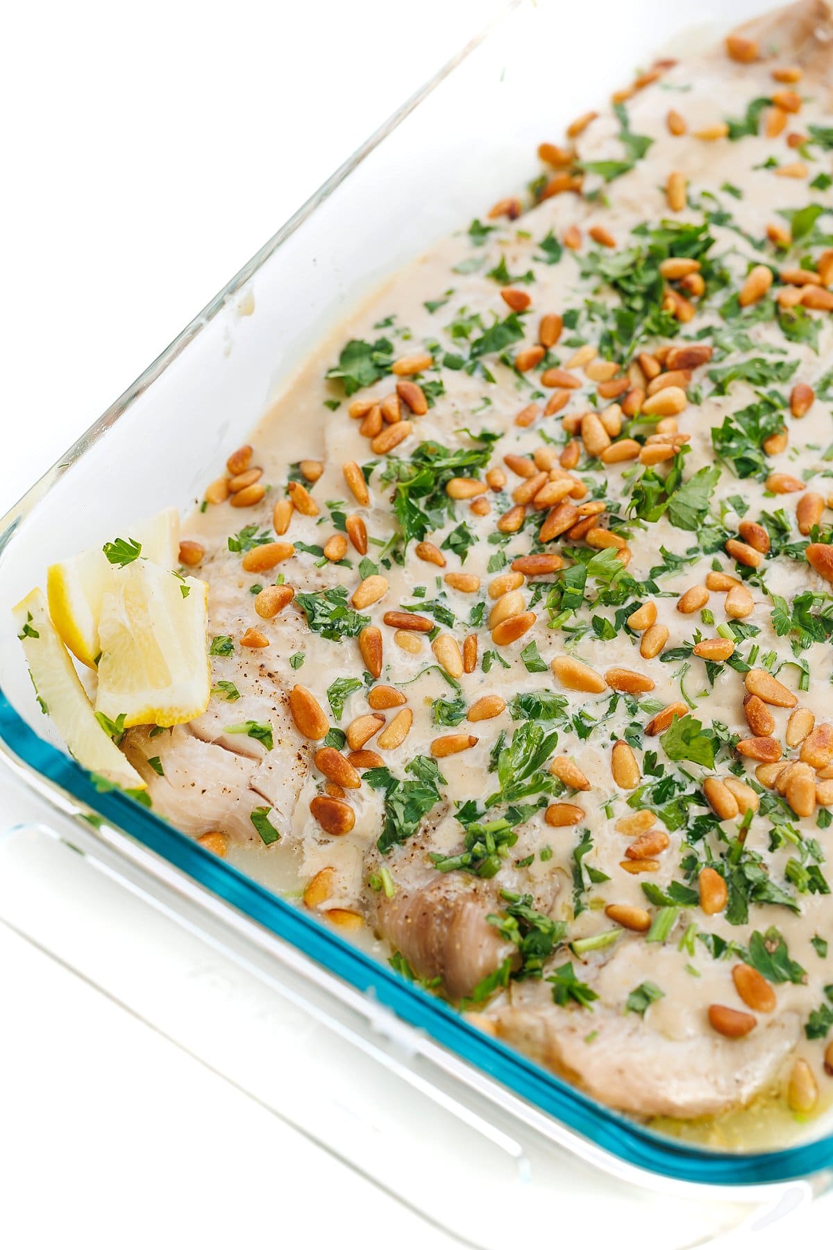 Lebanese baked fish with tahini sauce and toasted pine nuts.