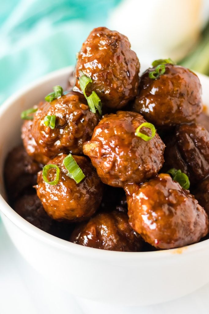 white bowl stacked high with honey garlic meatballs made in the crockpot