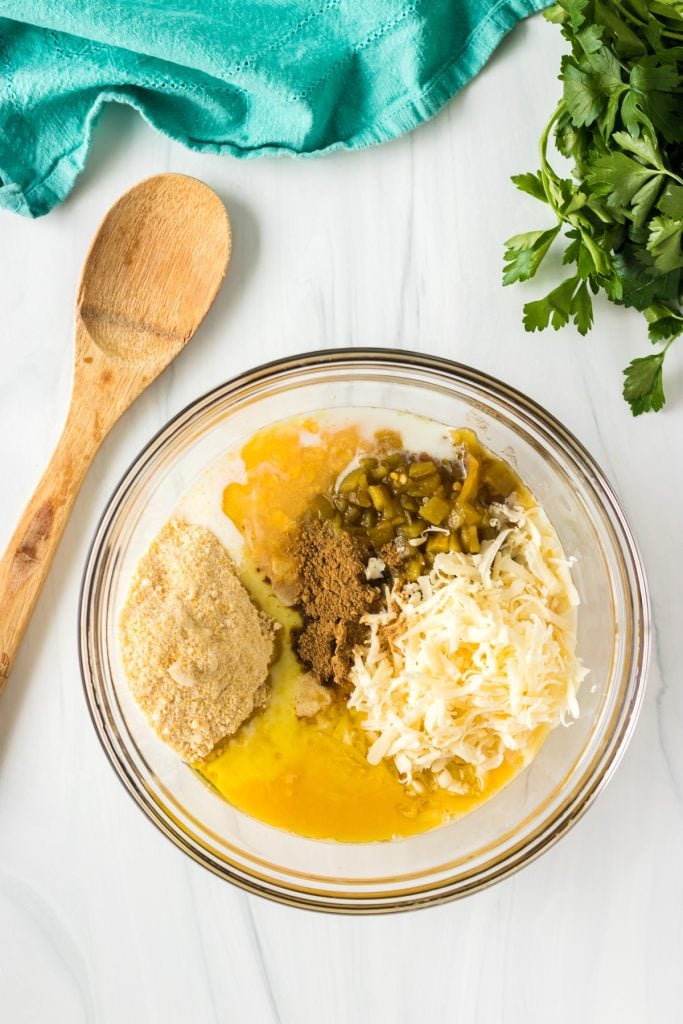 mixing bowl filled with ingredients for corn casserole waiting to be stirred