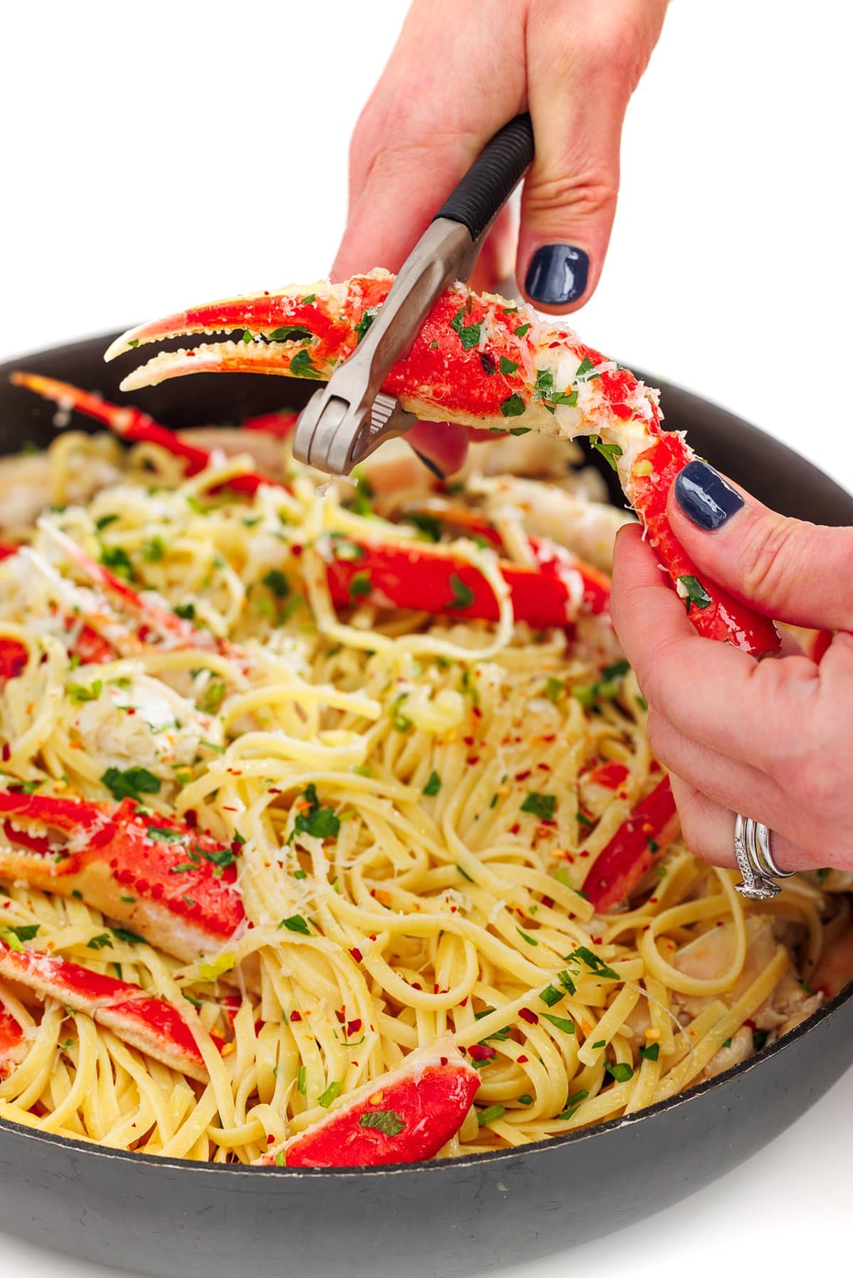 Liz using a shellfish cracker to crack open a crab claw for crab linguine in a white wine garlic sauce.