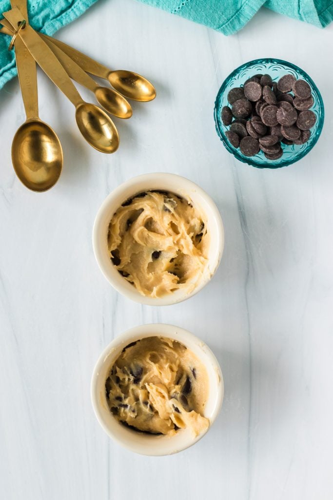 two ramekins filled with chocolate chip cookie dough