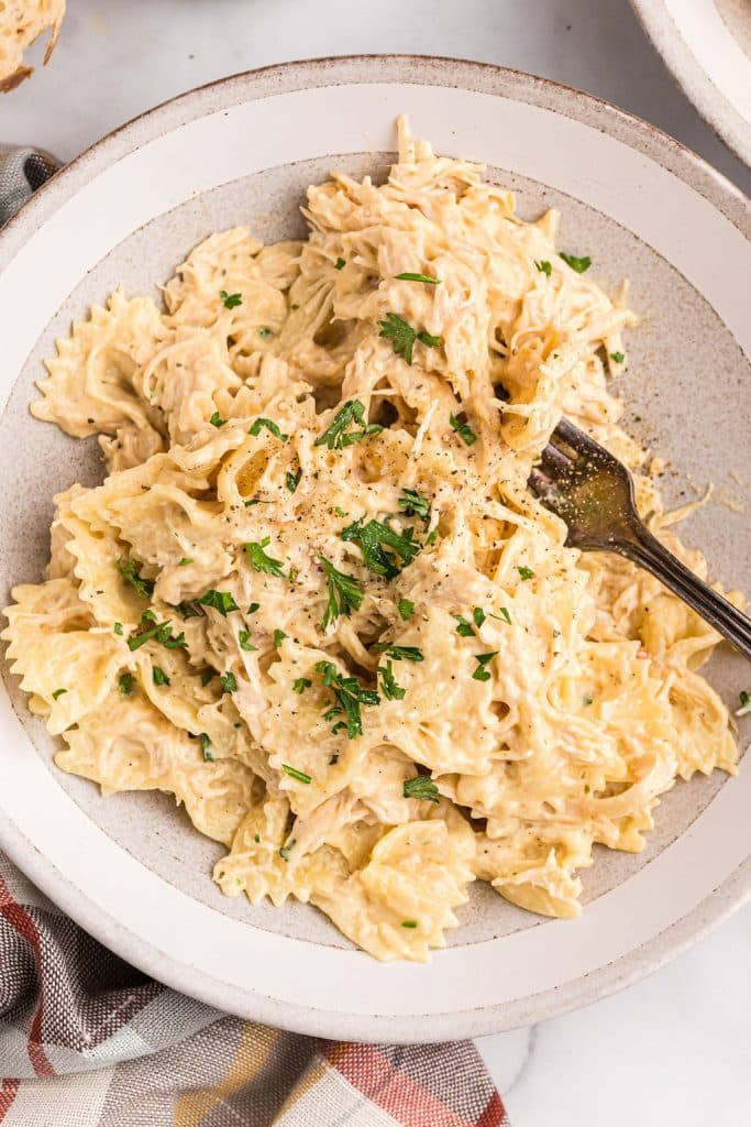 overhead shot of creamy italian chicken on bowtie noodles.