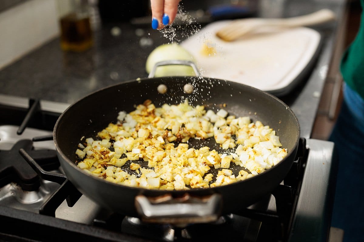 Cooking diced onion in a skillet.
