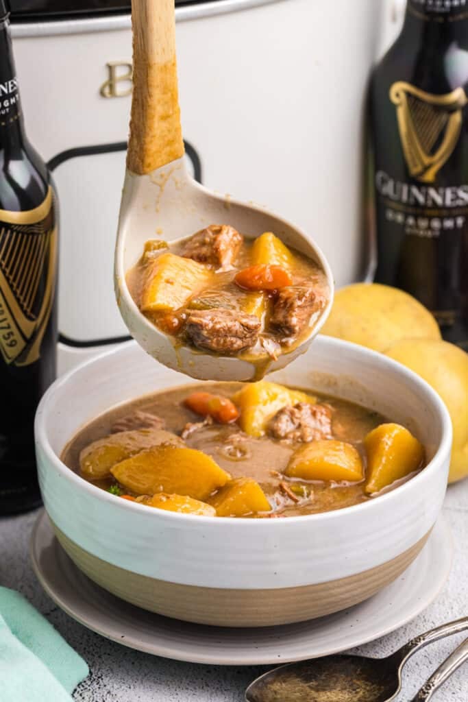 ladle serving beef stew into a bowl.