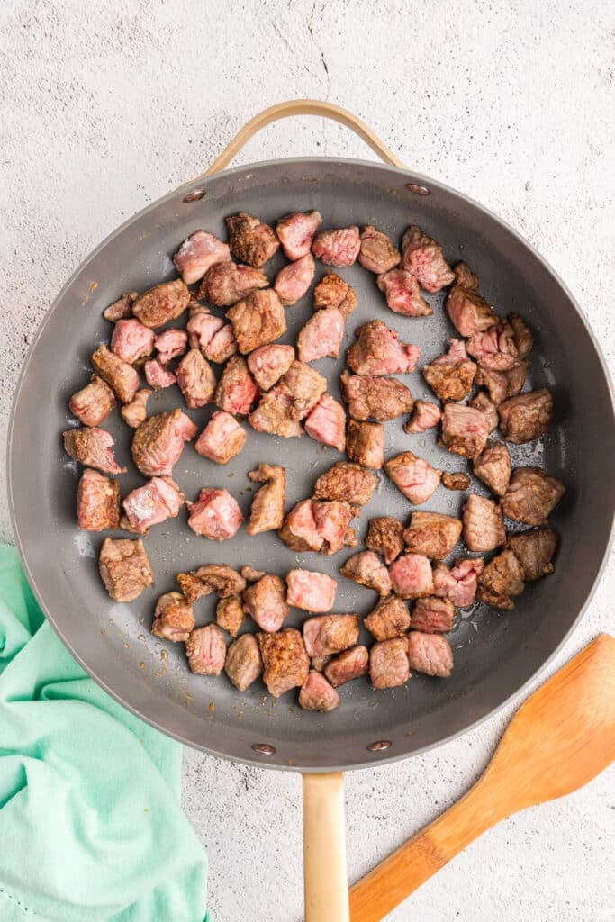 lightly browned stew beef pieces in a skillet.