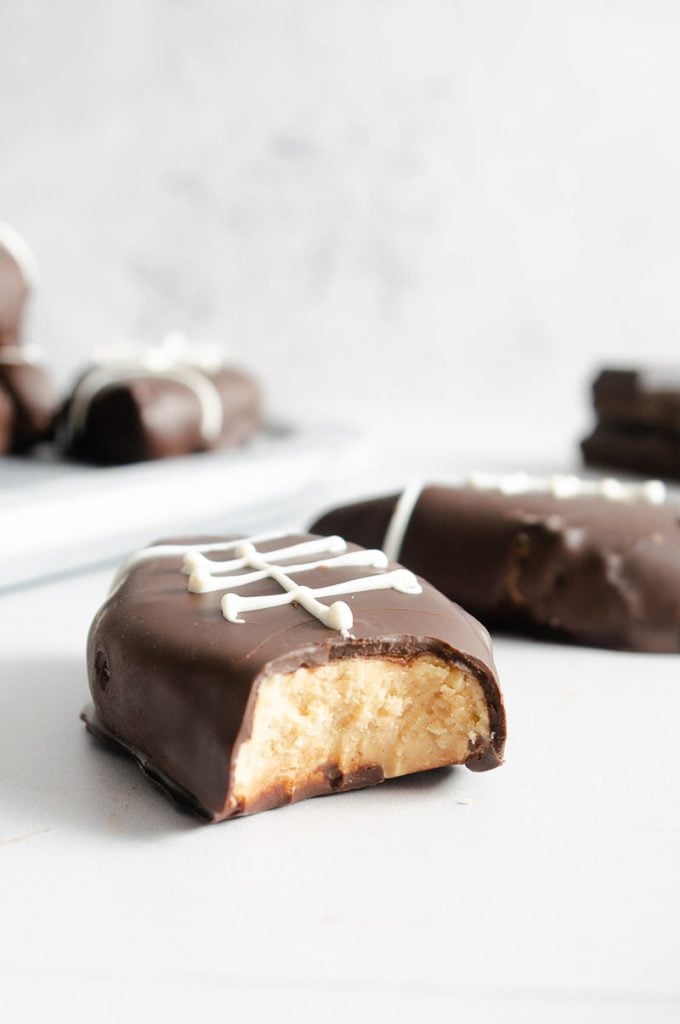 chocolate covered peanut butter football with a bite taken out of it.