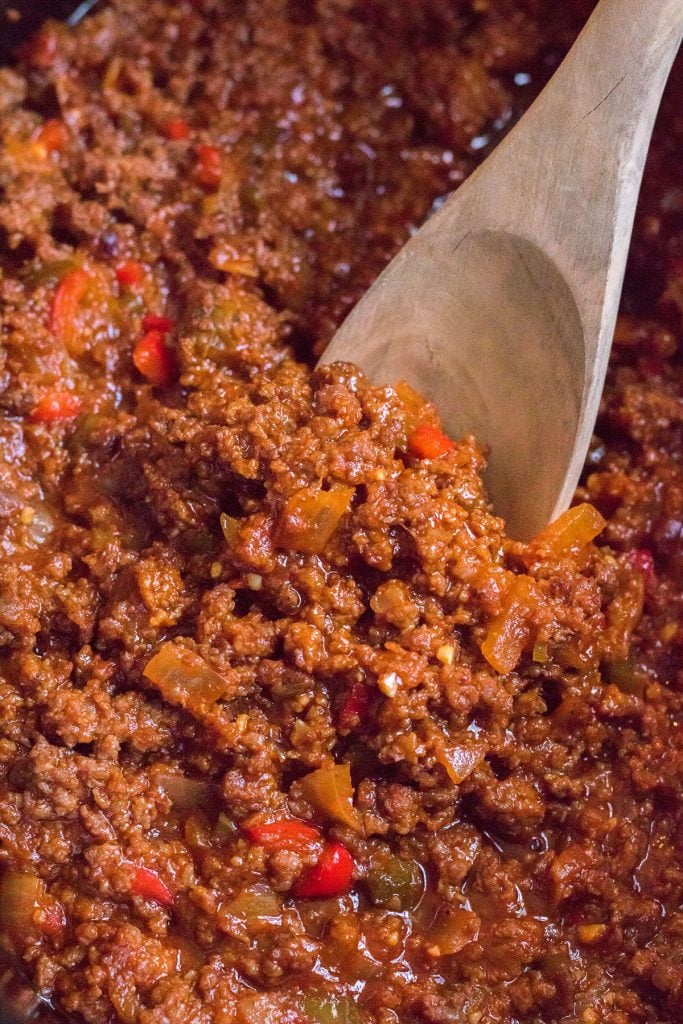 closeup of a wooden spoon in sloppy joe mixture.