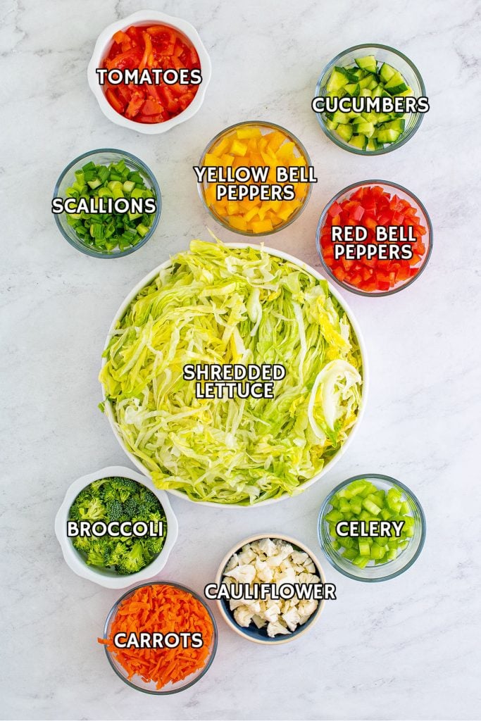 overhead shot of bowls holding diced vegetables prepped to make a salad.