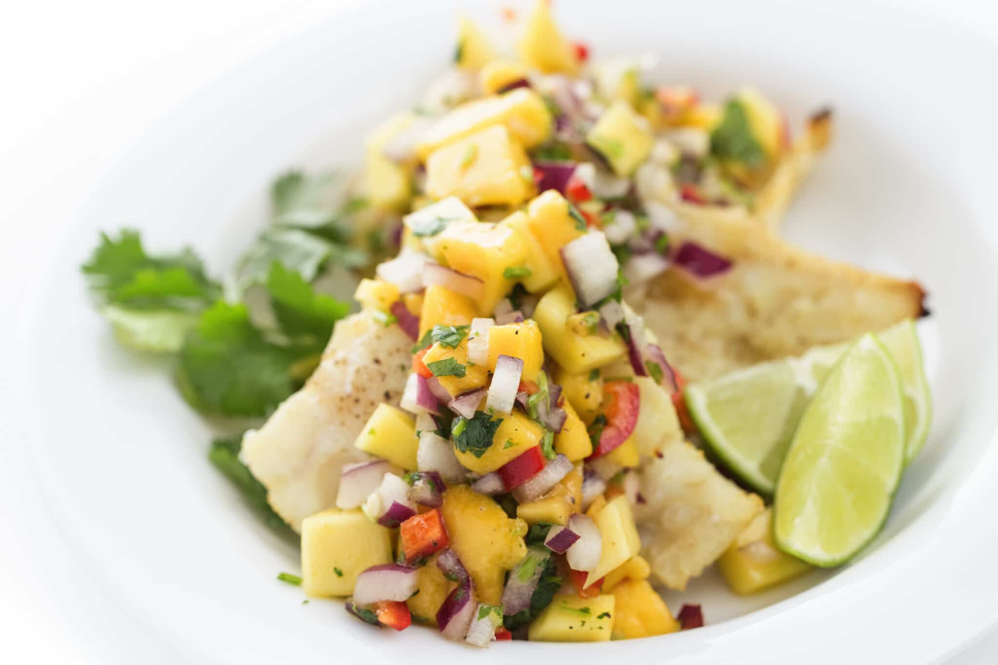 Broiled Whitefish with Mango Salsa and fresh lime slices.