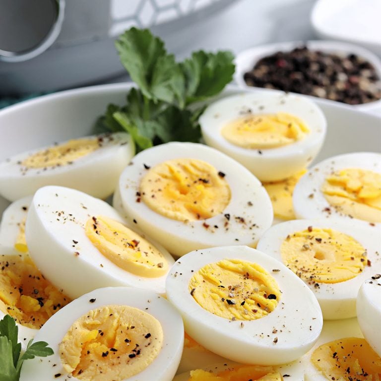 plate of sliced hard boiled eggs sprinkled with pepper.