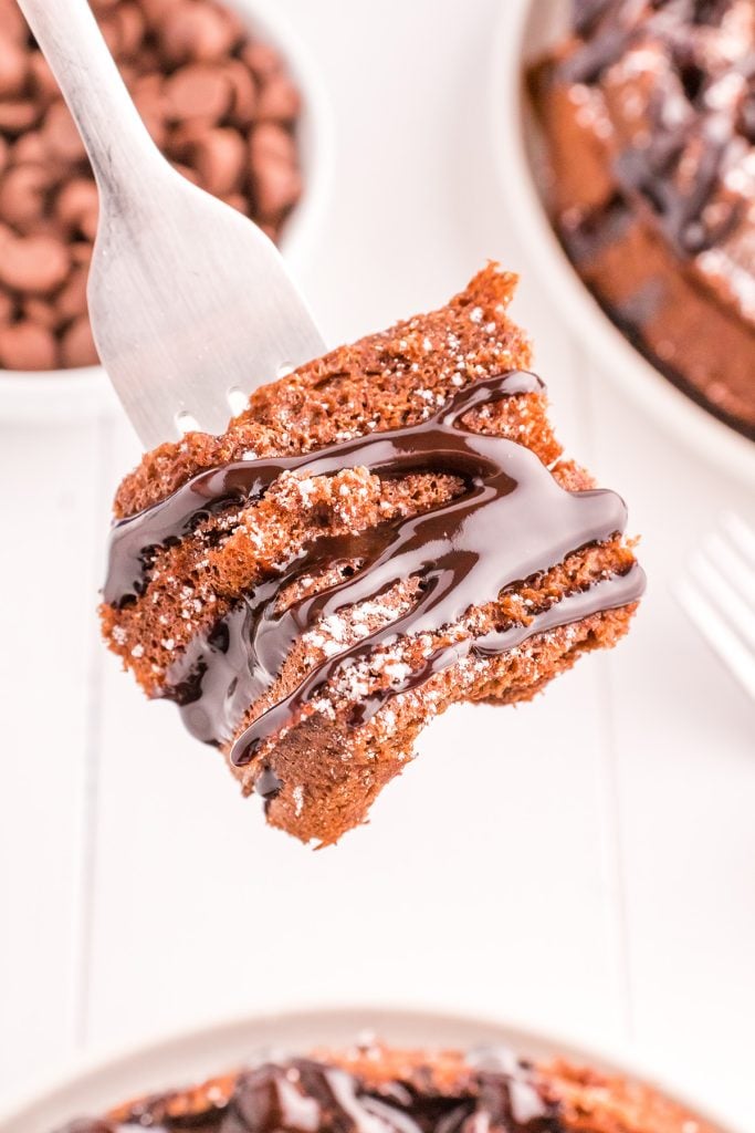 bite of chocolate sauce covered chocolate waffle on a fork.