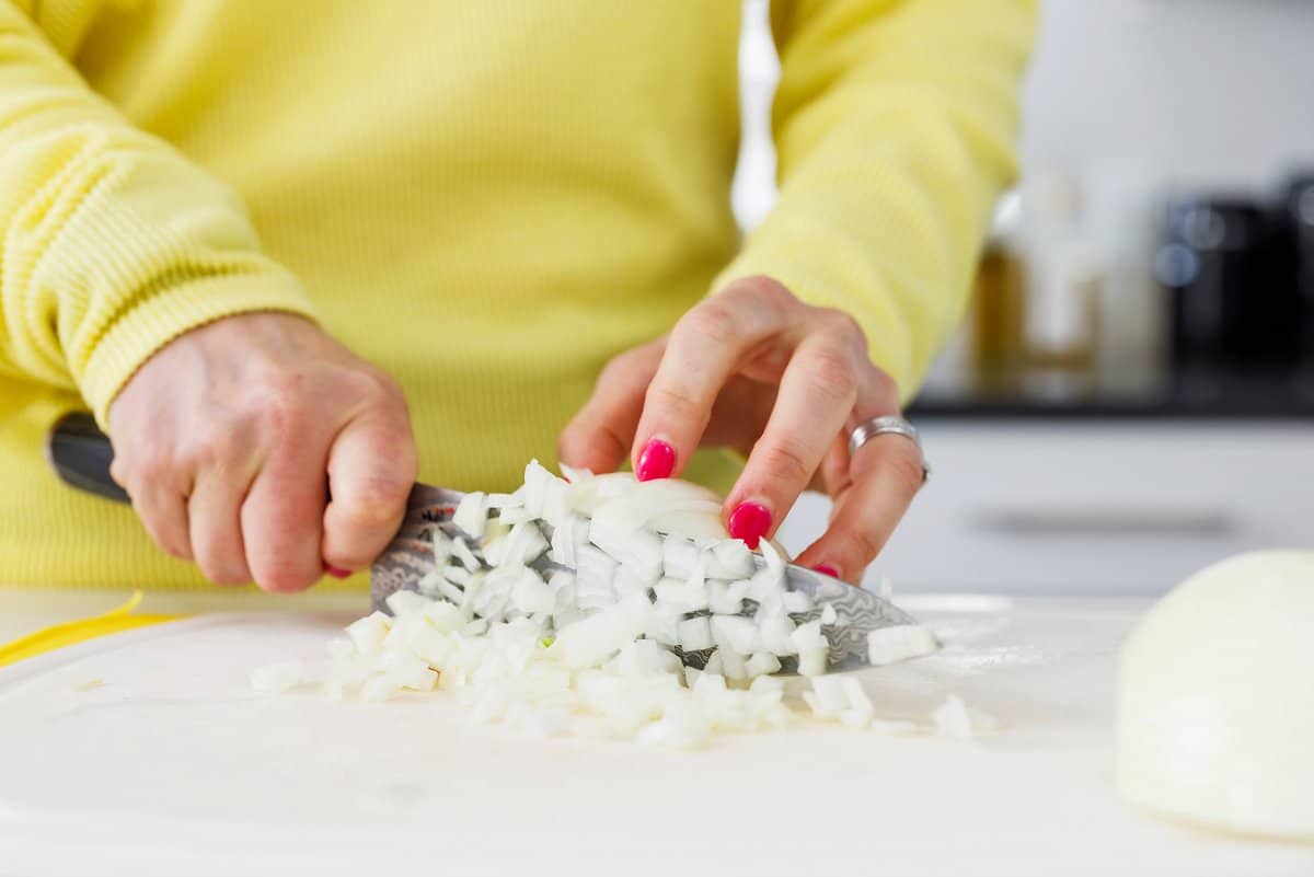 Liz dicing a white onion.