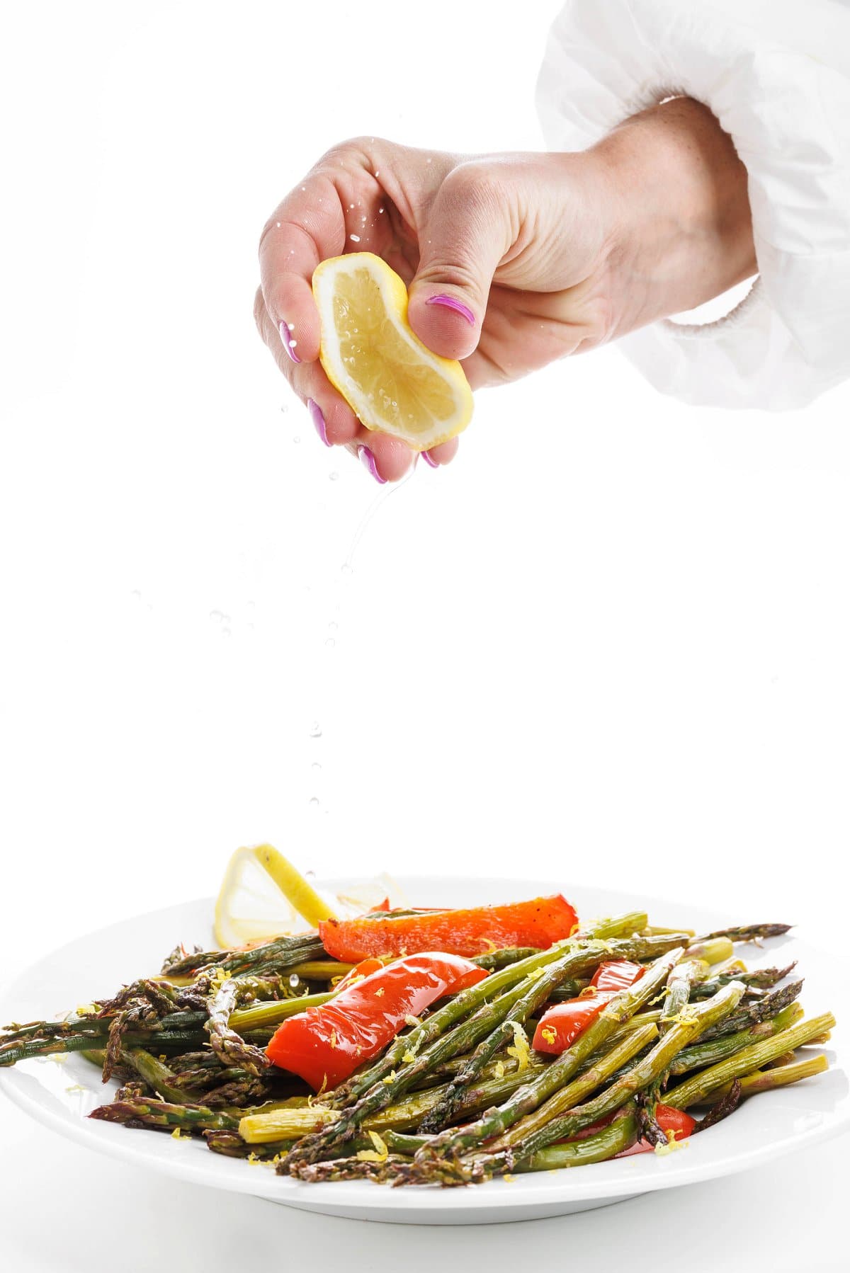 Garnishing roasted asparagus with red peppers.