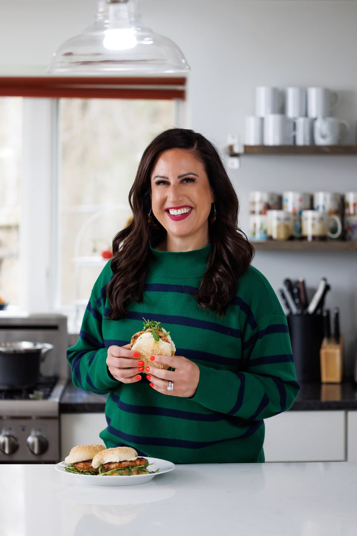 Liz eating grilled turkey burgers with pesto.