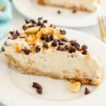 slice of frozen peanut butter pie topped with peanuts & chocolate chips.