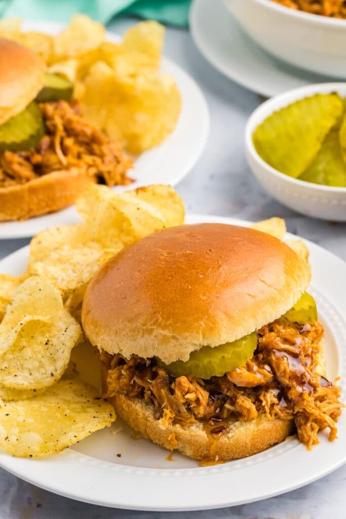 hot honey chicken sandwiches on a plate with chips.
