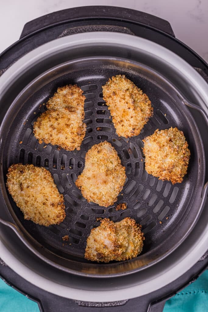 boneless chicken wings in an air fryer basket.