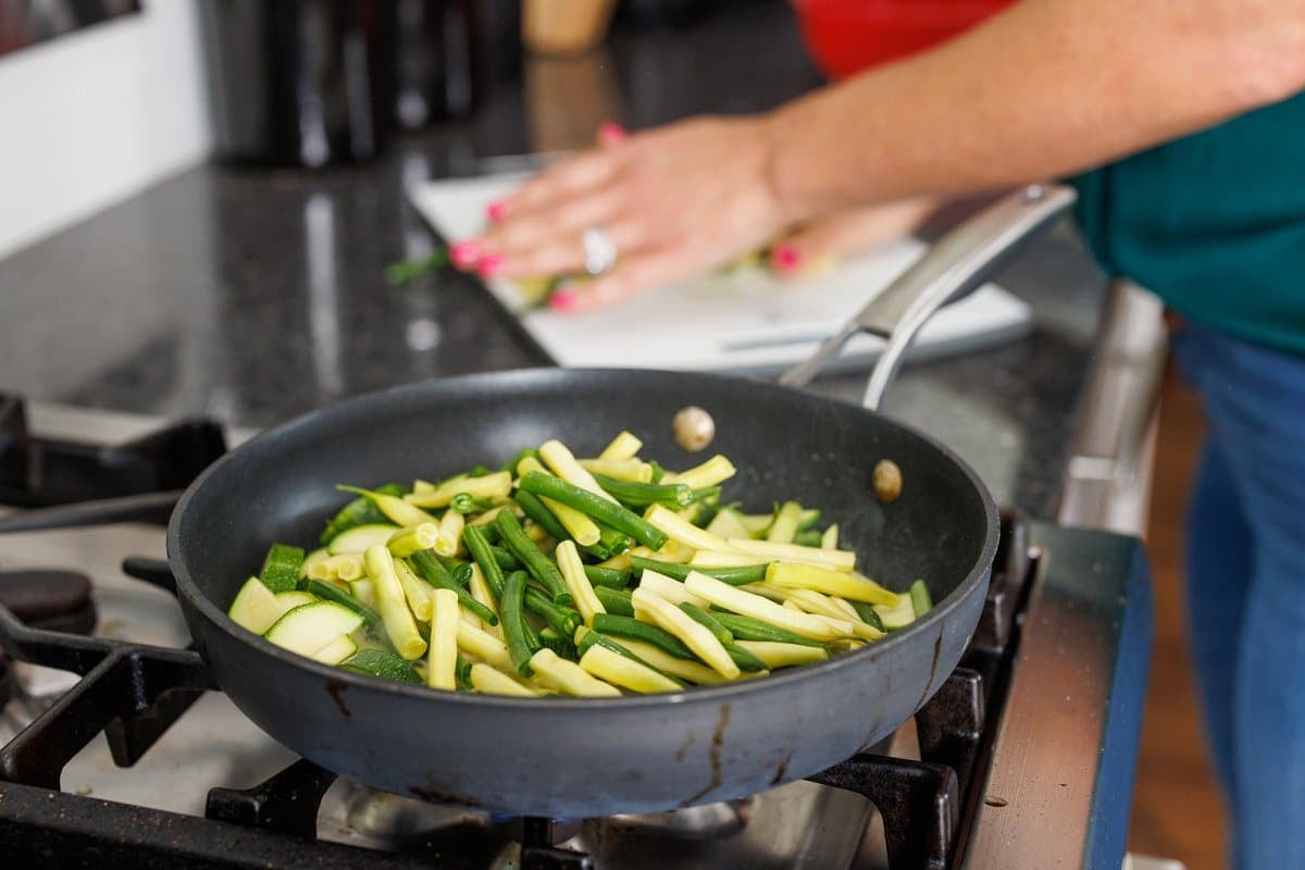 Green beans added to sauté pan.