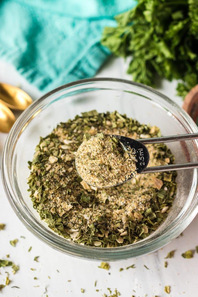 teaspoon holding ranch seasoning mix over a bowl.