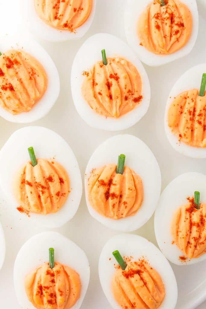 overhead shot of deviled eggs shaped liked pumpkins.