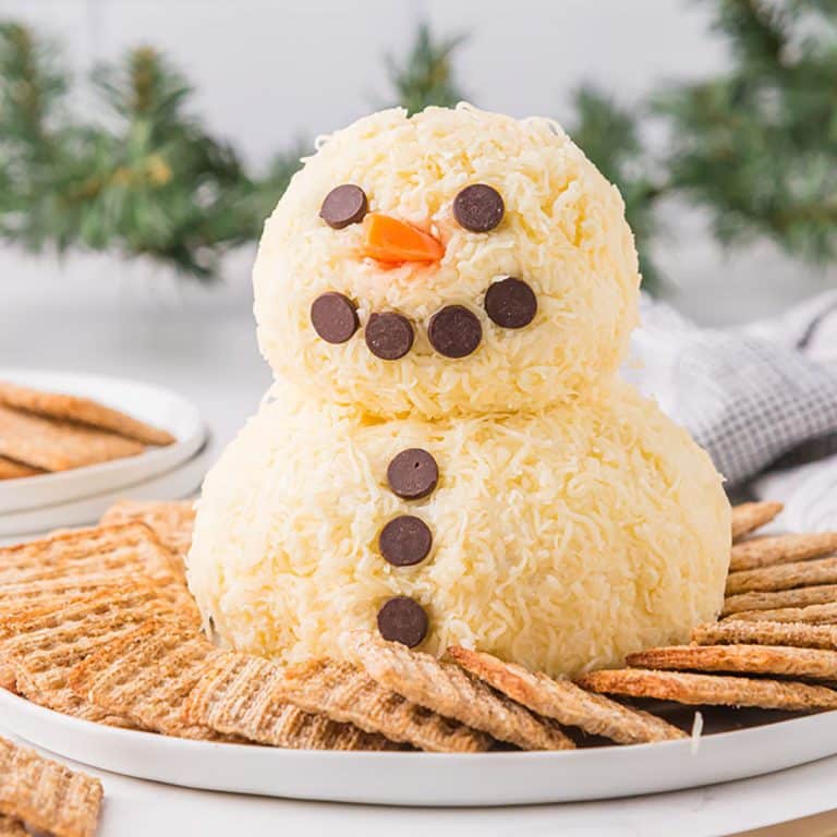 snowman cheeseball surrounded by crackers.