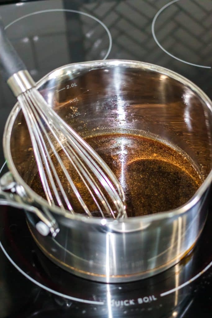 whisk in a saucepan on a stovetop.