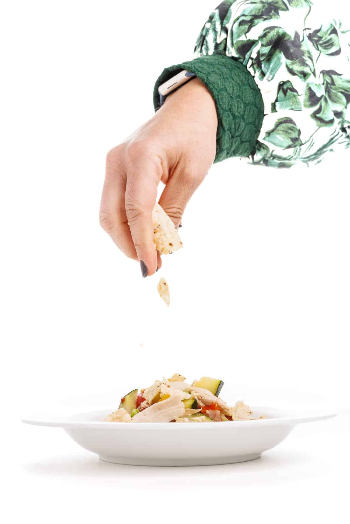 Garnishing chicken tortilla soup with hominy.