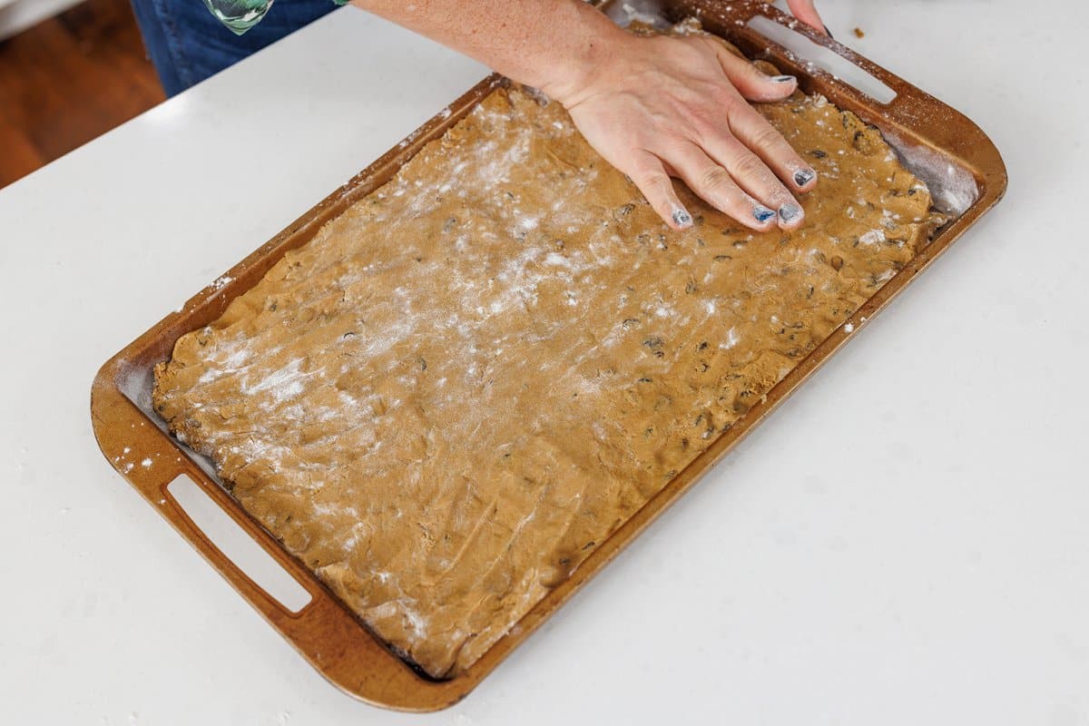 Liz pressing out hermit bar dough onto a prepared baking pan.