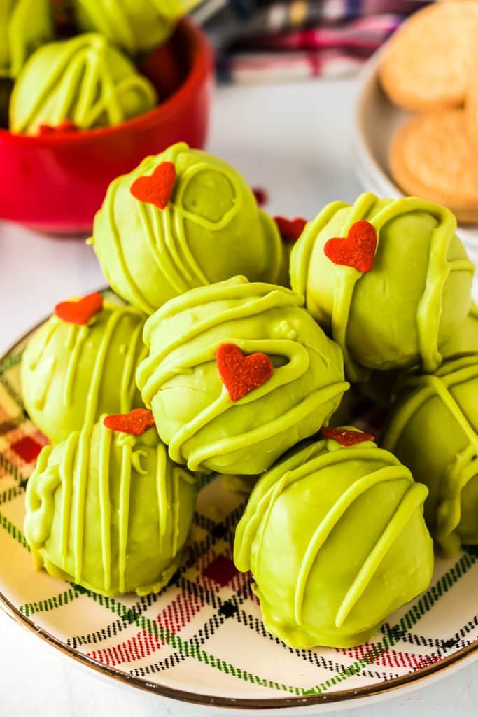 a platter of grinch oreo truffles with red heart sprinkles.