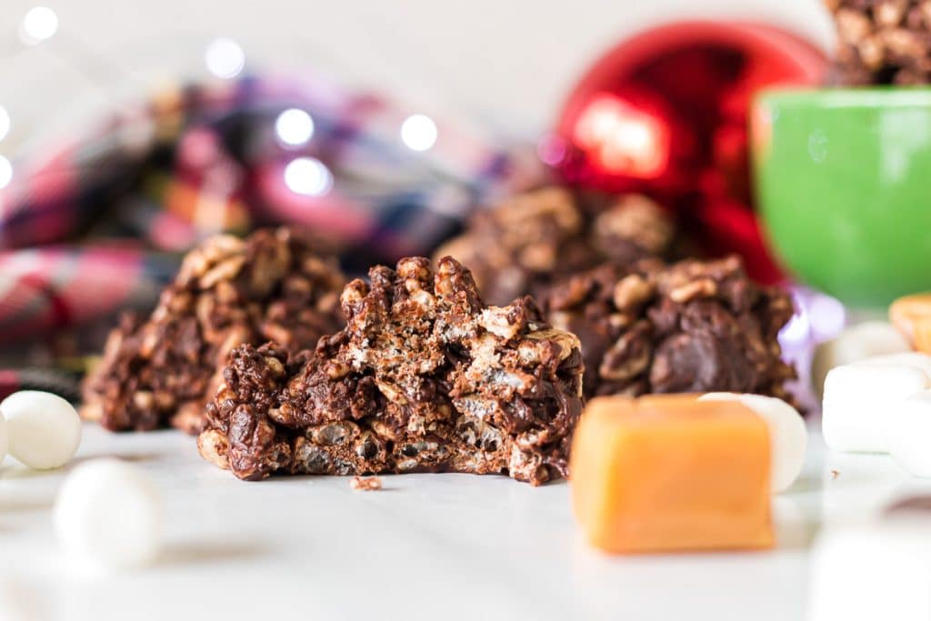 side view of a reindeer poop chocolate cookie with a bite missing.