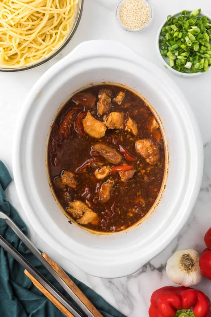 honey garlic chicken noodles in a white slow cooker.