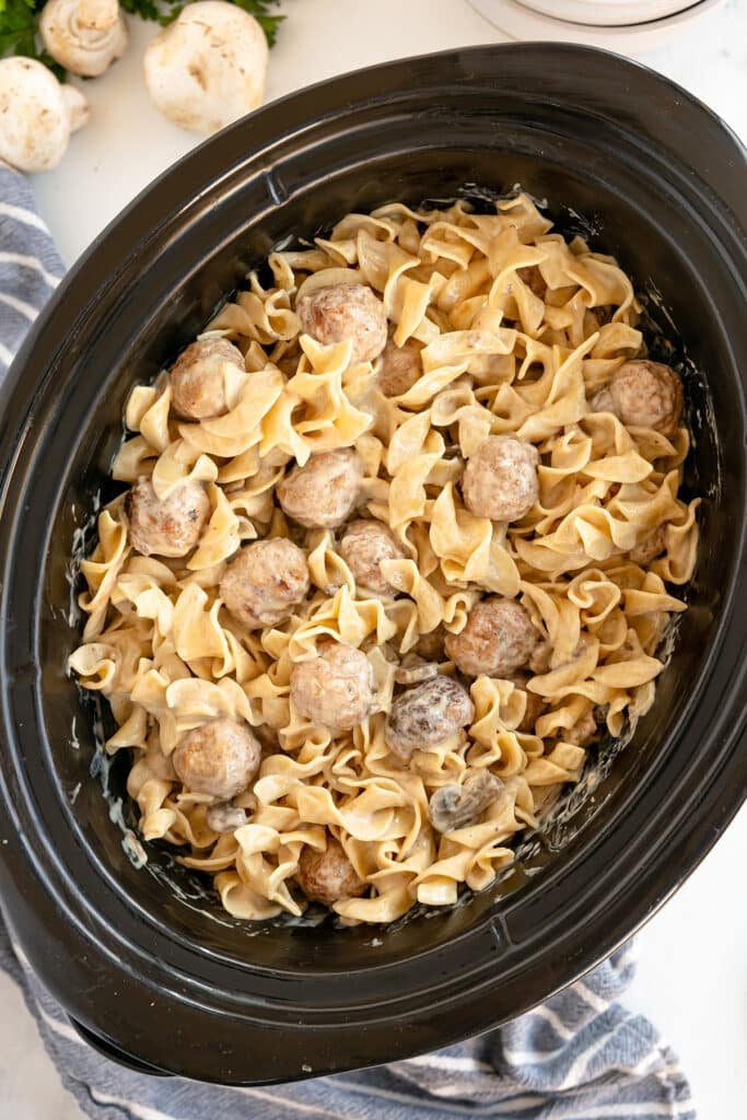 overhead shot of meatball stroganoff in a black crockpot.