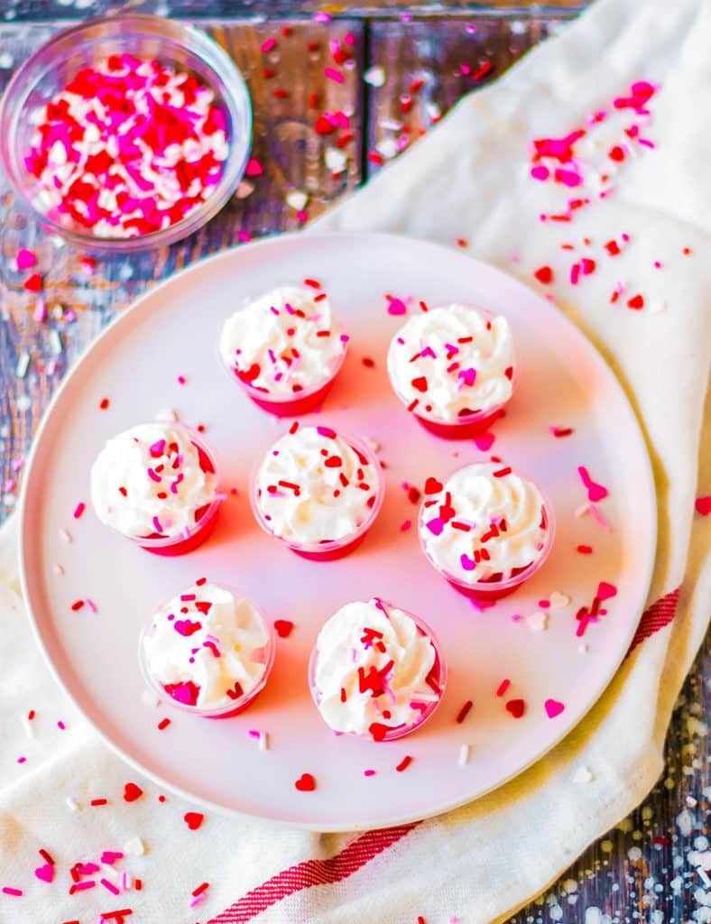 overhead shot of valentine's day jello shots on a white plate.