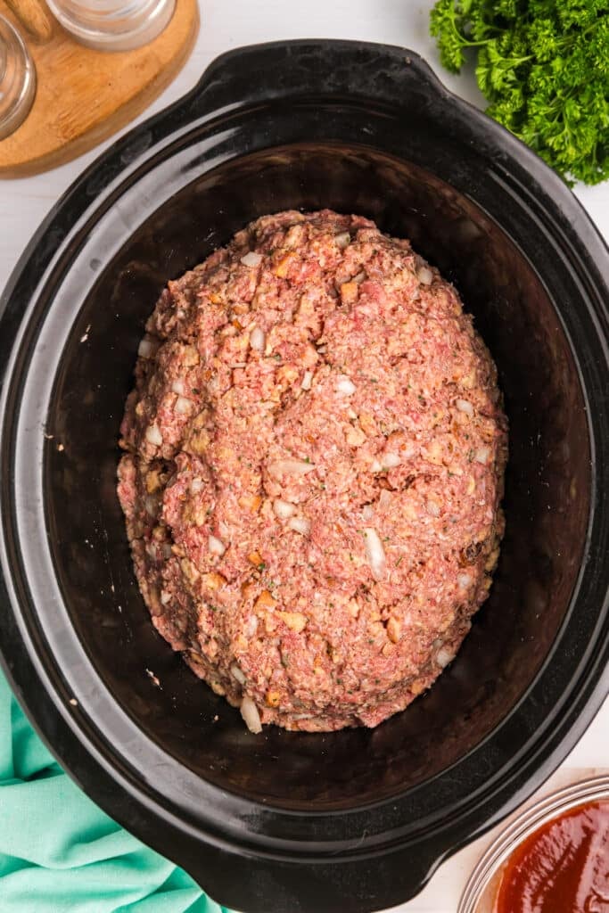 formed meatloaf in a black crockpot.