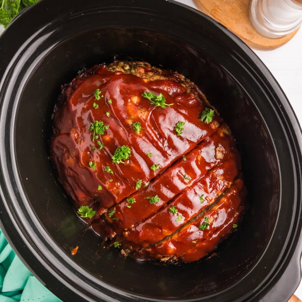 overhead shot of sliced meatloaf in a crockpot.