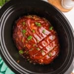overhead shot of sliced meatloaf in a crockpot.