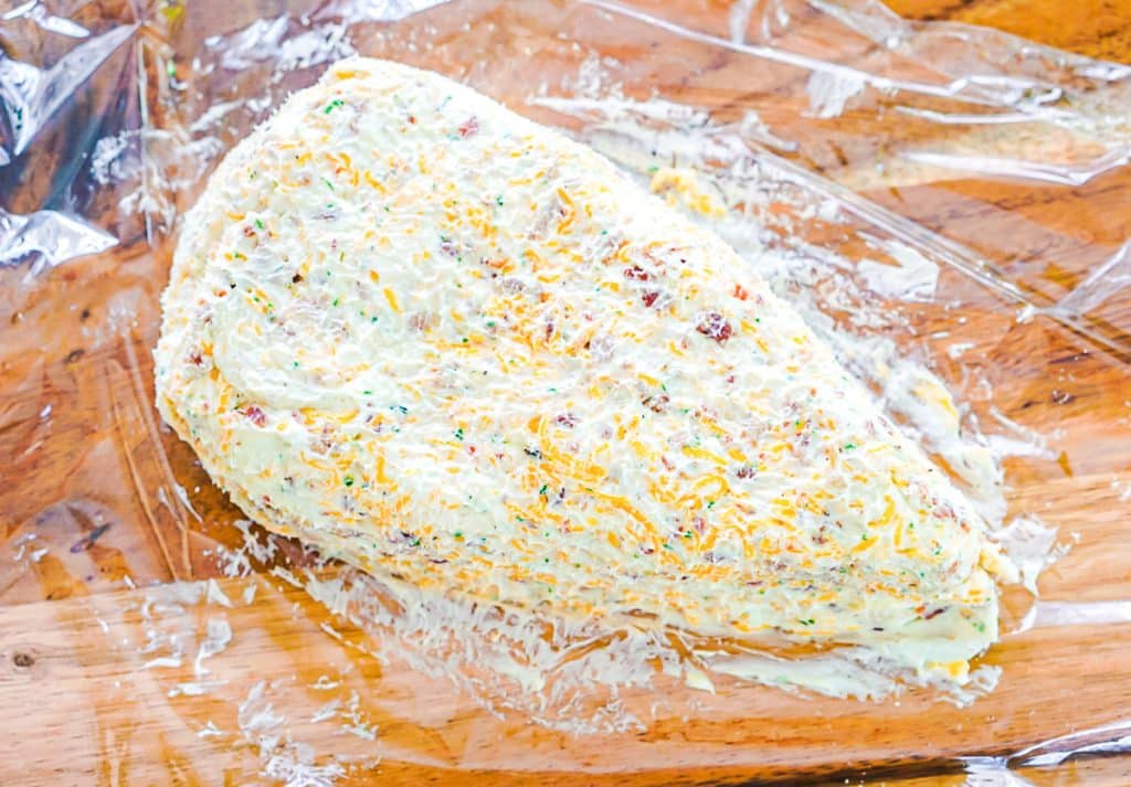 cheese ball on a board shaped like a carrot.