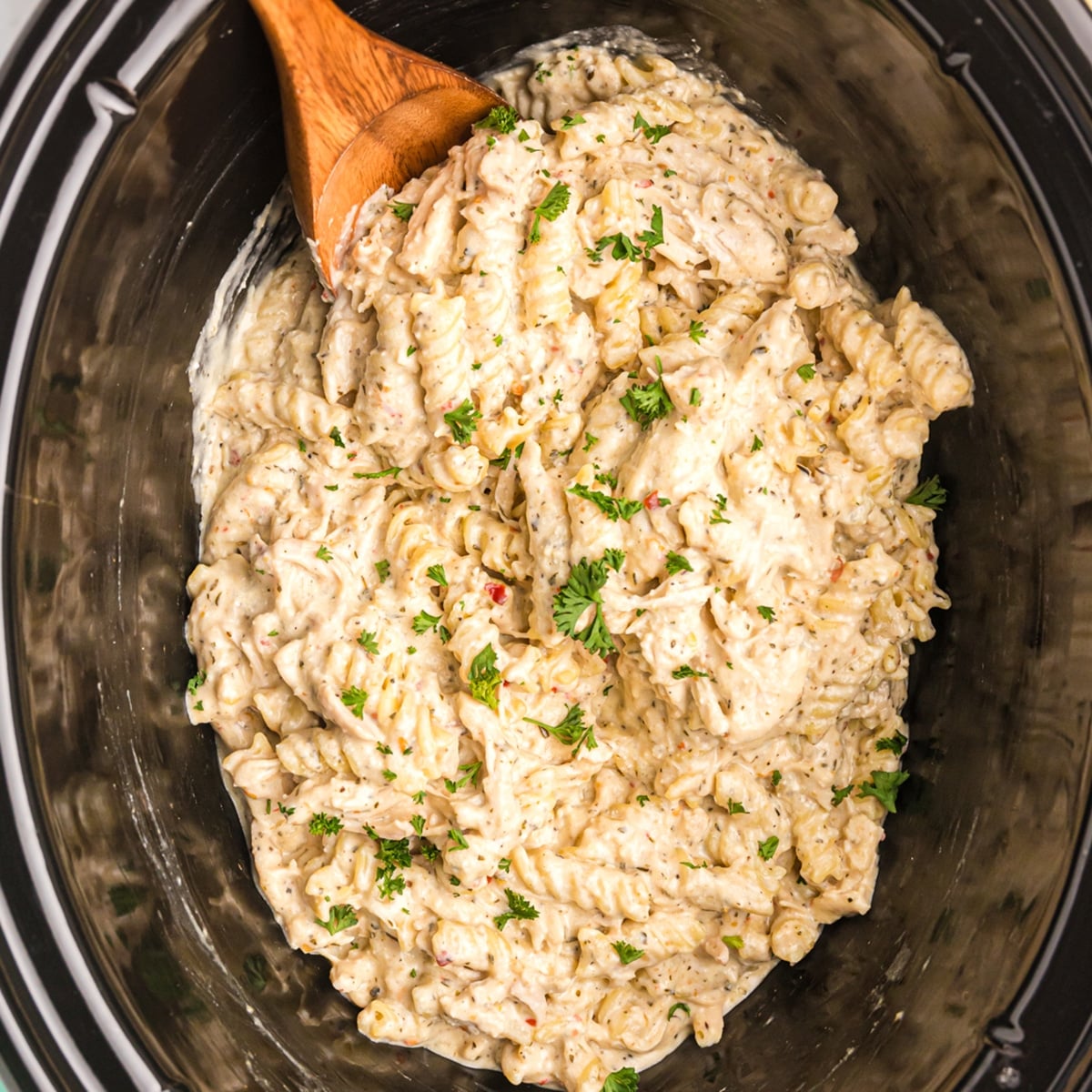 overhead shot of garlic parmesan chicken pasta in a slow cooker.