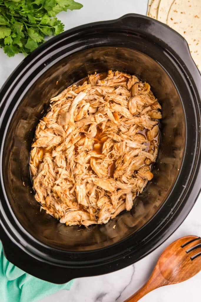 overhead shot of shredded honey lime chicken in a crockpot.