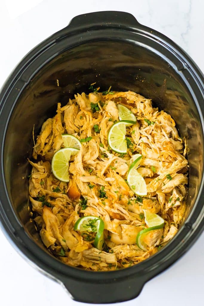 overhead shot of shredded honey lime chicken in a crockpot.