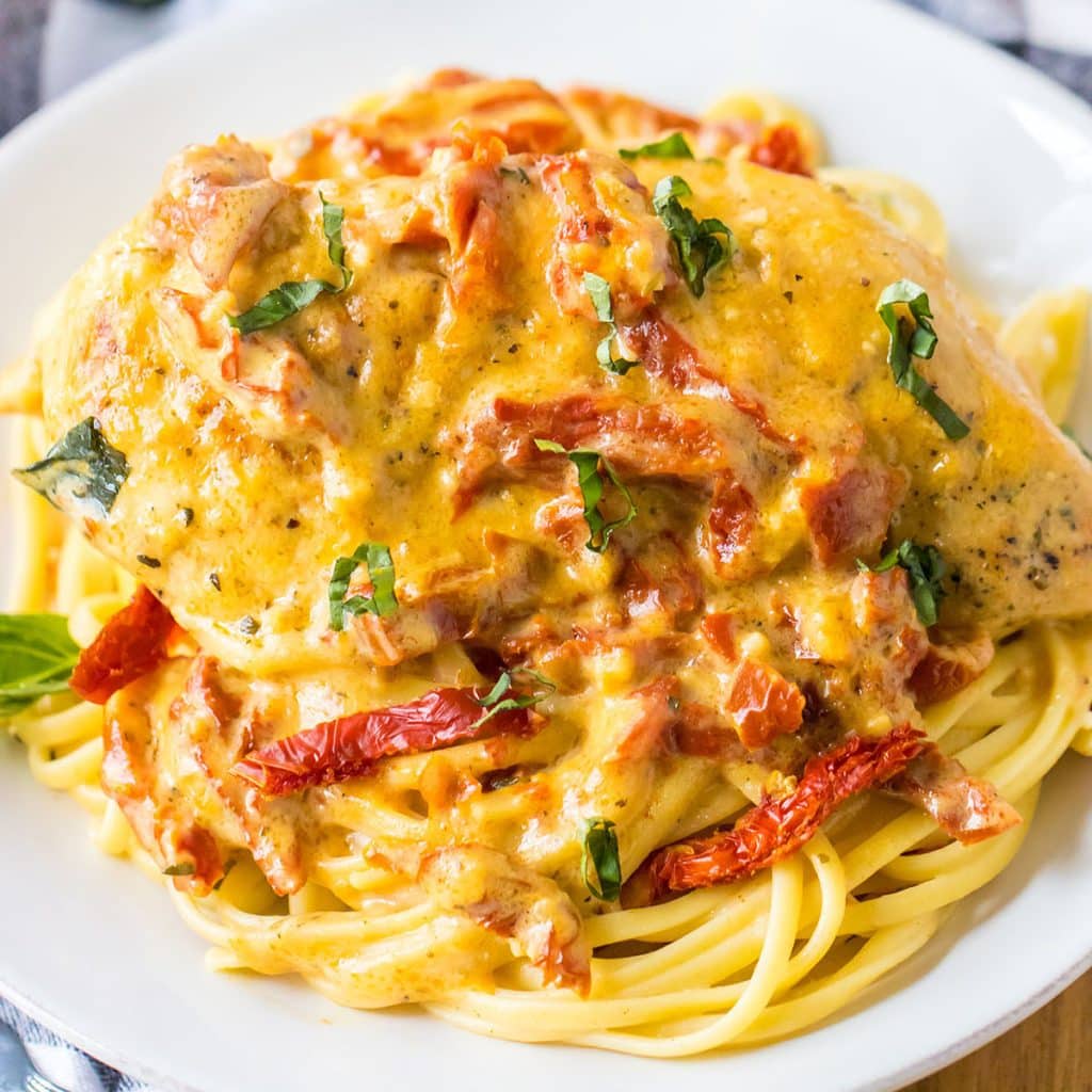 overhead shot of marry me chicken on a bed of noodles.