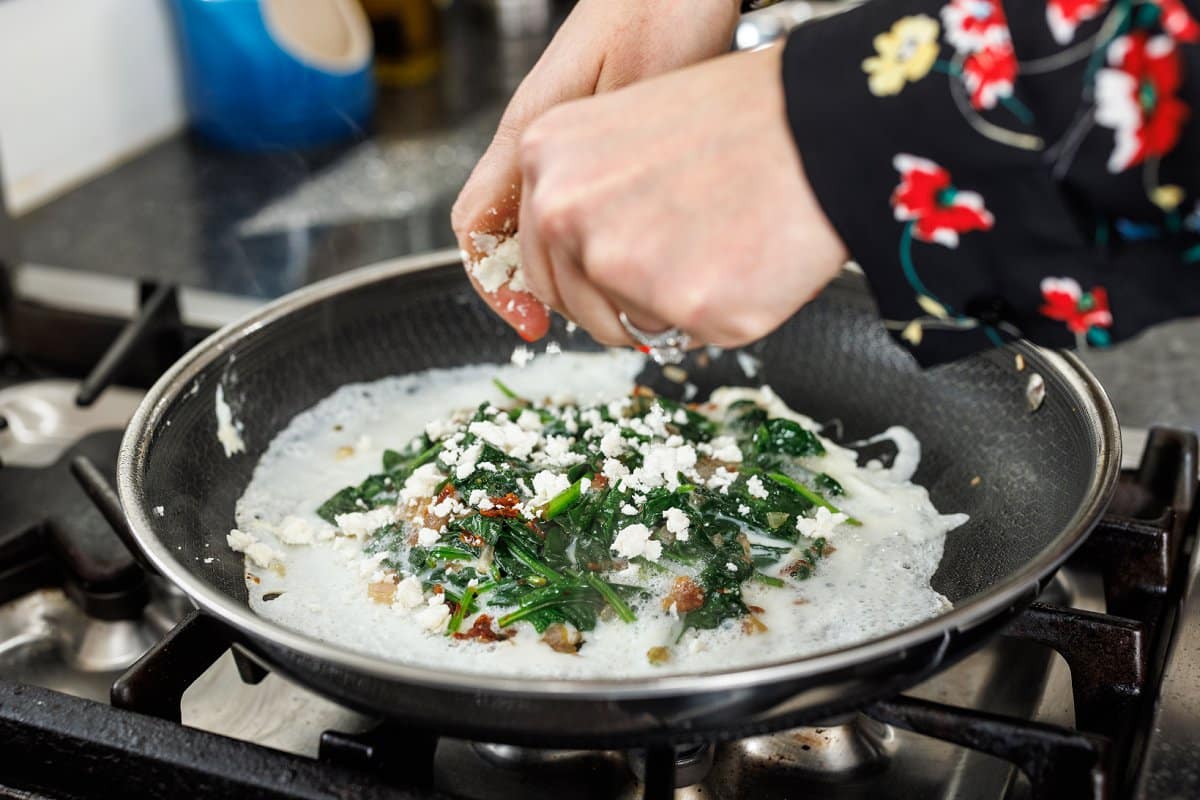 Crumbling feta cheese over omelette.