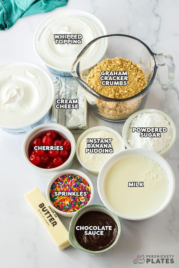 overhead shot of labeled ingredients laid out to make banana split dessert.