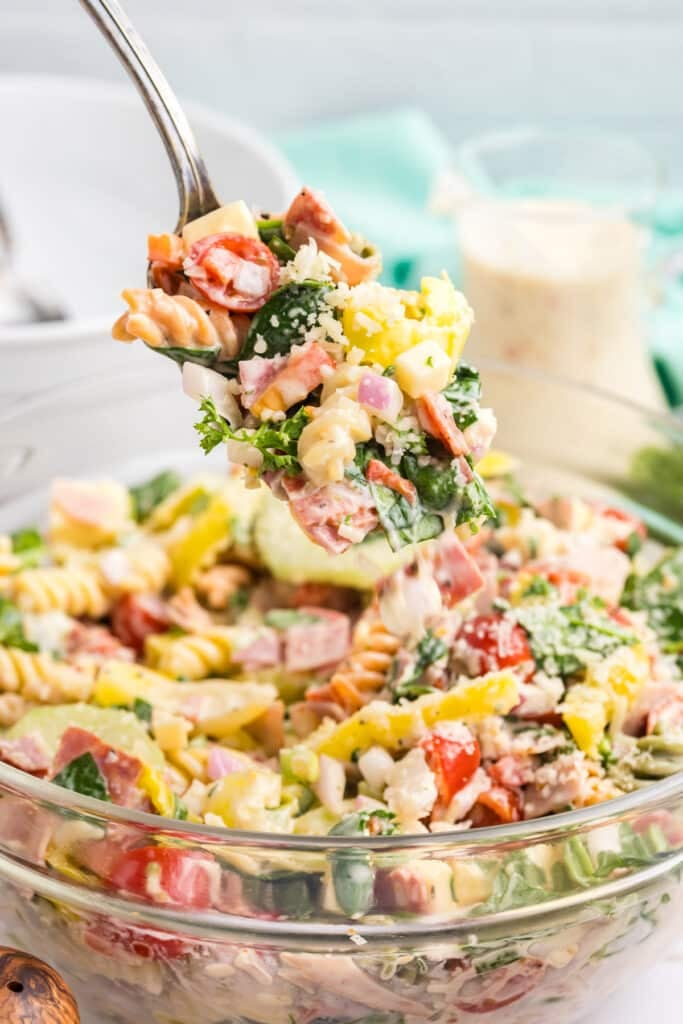 spoon scooping hoagie pasta salad from a bowl.