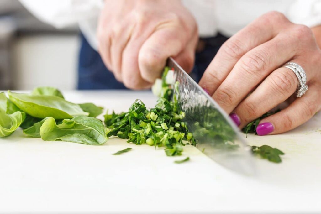 Liz cutting fresh herbs and scallions.