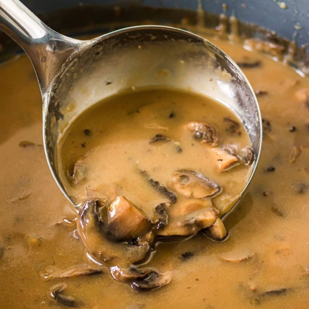 ladle scooping mushroom gravy.